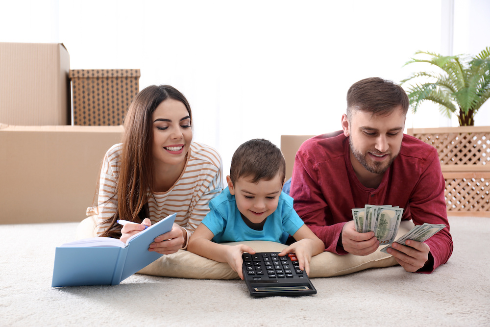 Happy family with money on floor at home