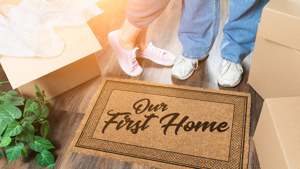 Feet view of couple standing in front of first home door mat